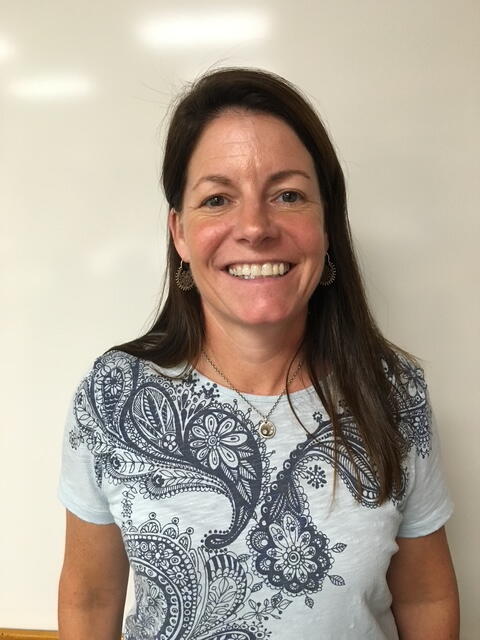 This photo shows Kate Rogan. She's wearing a gray T-shirt with dark gray paisleys on it.