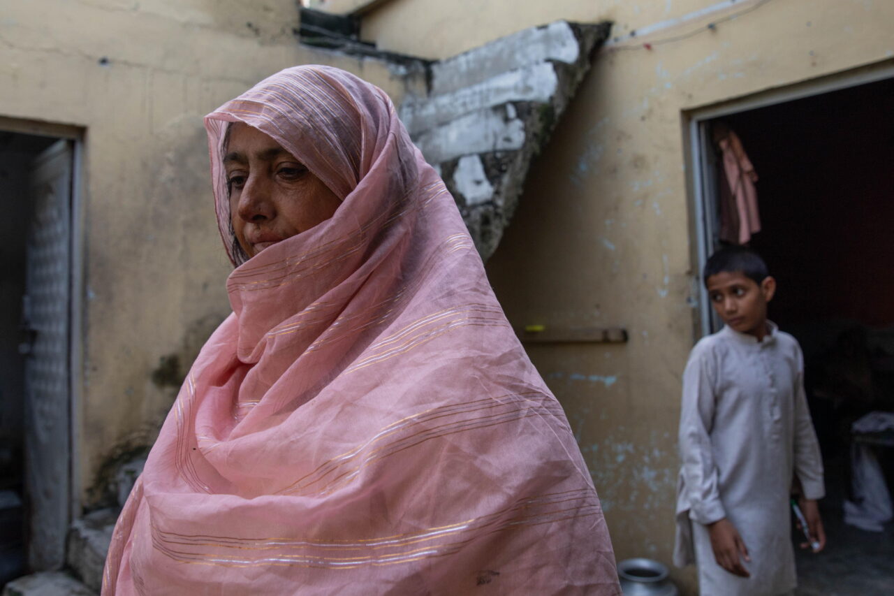 Saida Tanvir stands inside her partially damaged home near Bari Imam on August 20, 2026 in Islamabad, Pakistan. Her son Azeem Ahmed, 16, died while trying to block a bulldozer from crushing their roadside grocery store over the winter.