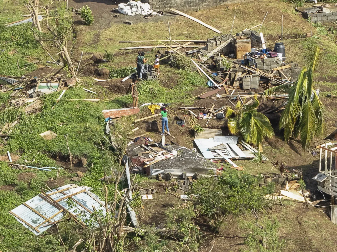 Family members survey their home destroyed in the passing of Hurricane Beryl, in Ottley Hall, St. Vincent and the Grenadines, Tuesday, July 2, 2024.
