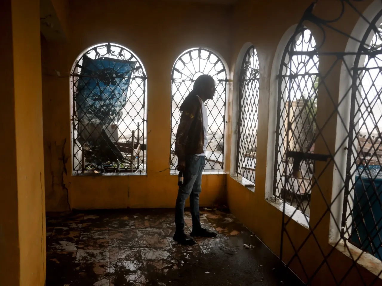 Marvin Williams stands on his muddy porch after ocean water reached his home as Hurricane Beryl passed through the area on July 03, 2024, in Kingston, Jamaica. Beryl has caused widespread damage in several island nations as it continues to cross the Caribbean.