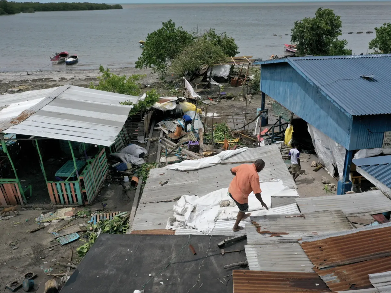 Jungle Simons fixes the roof on a building after Hurricane Beryl passed through the area on July 04, 2024, in Old Harbor, Jamaica. Hurricane Beryl, now a Category 3 storm, continues toward Mexico after passing through Caribbean islands, including Jamaica.