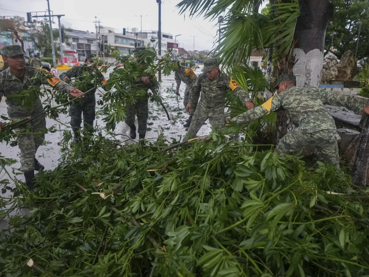 Soldiers collect branches felled by Hurricane Beryl, in Tulum, Mexico, Friday, July 5, 2024.