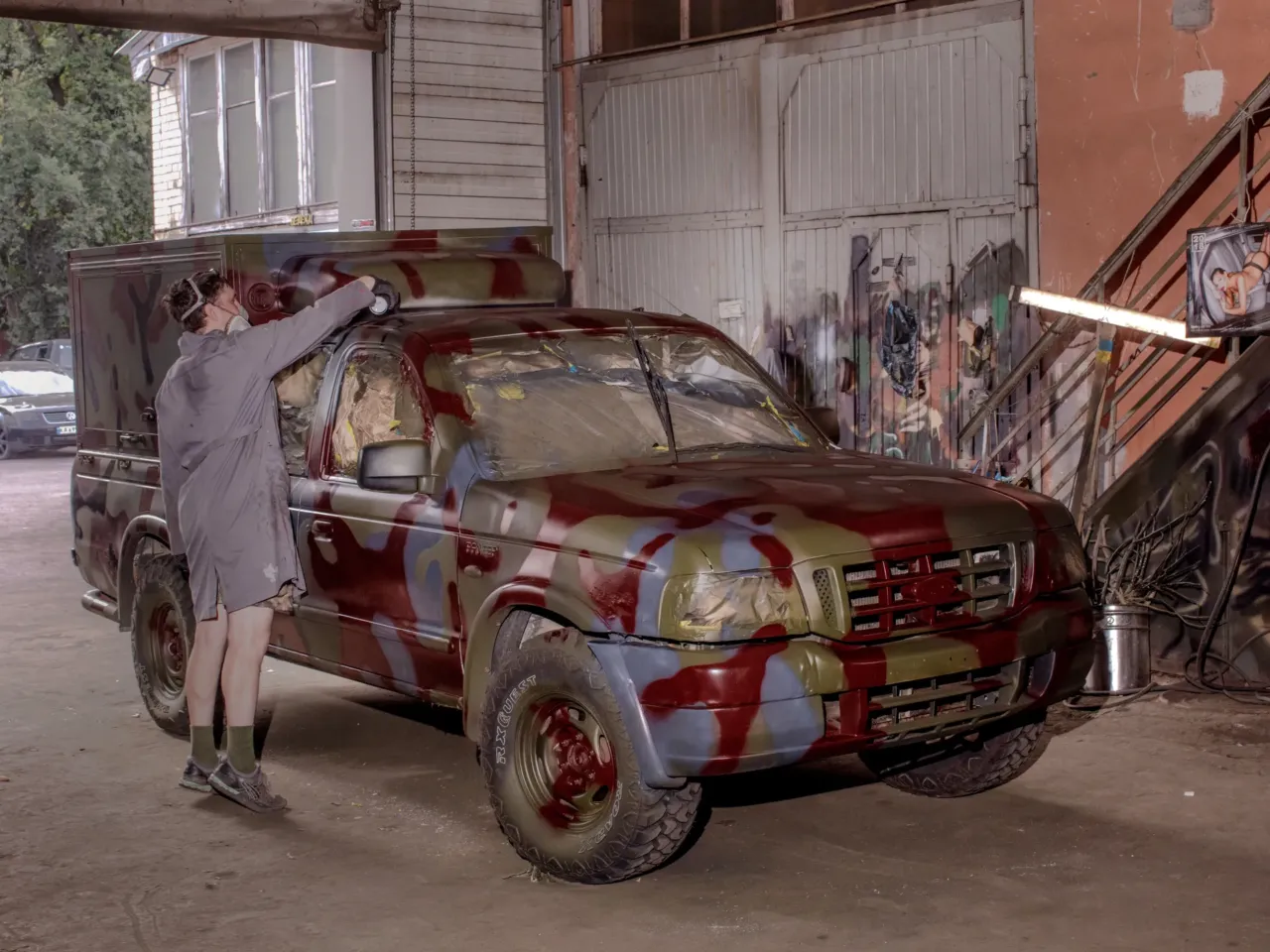 How these Ukrainian artists are using their talents to support the war effort 1 A painter adds dark red spots to a truck to camouflage with the reddish dirt and mud often found in Ukraine's east and south.