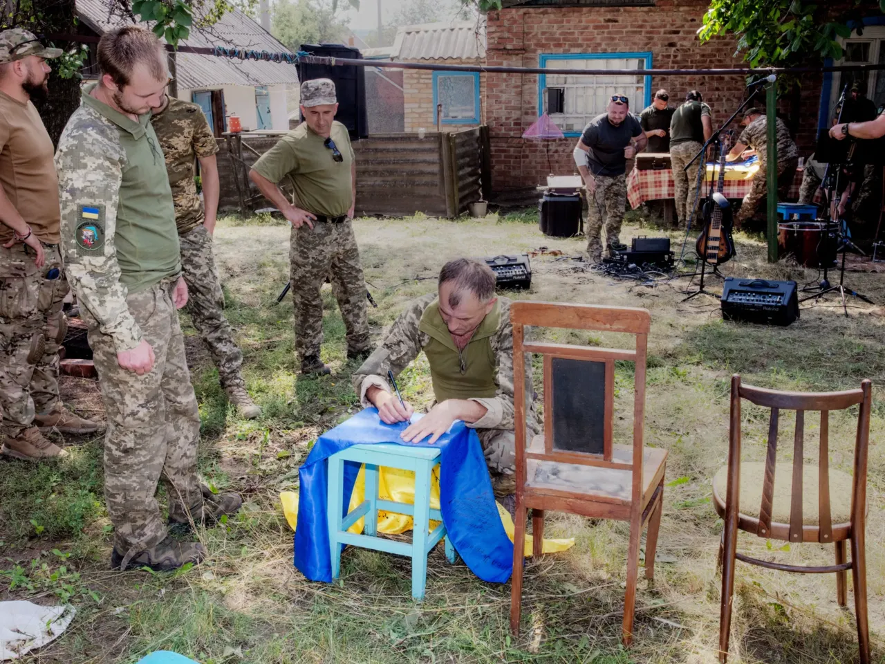 How these Ukrainian artists are using their talents to support the war effort 18 After a band of soldiers plays a concert for fellow troops near the front lines, the whole unit who attended signs a flag for the band.