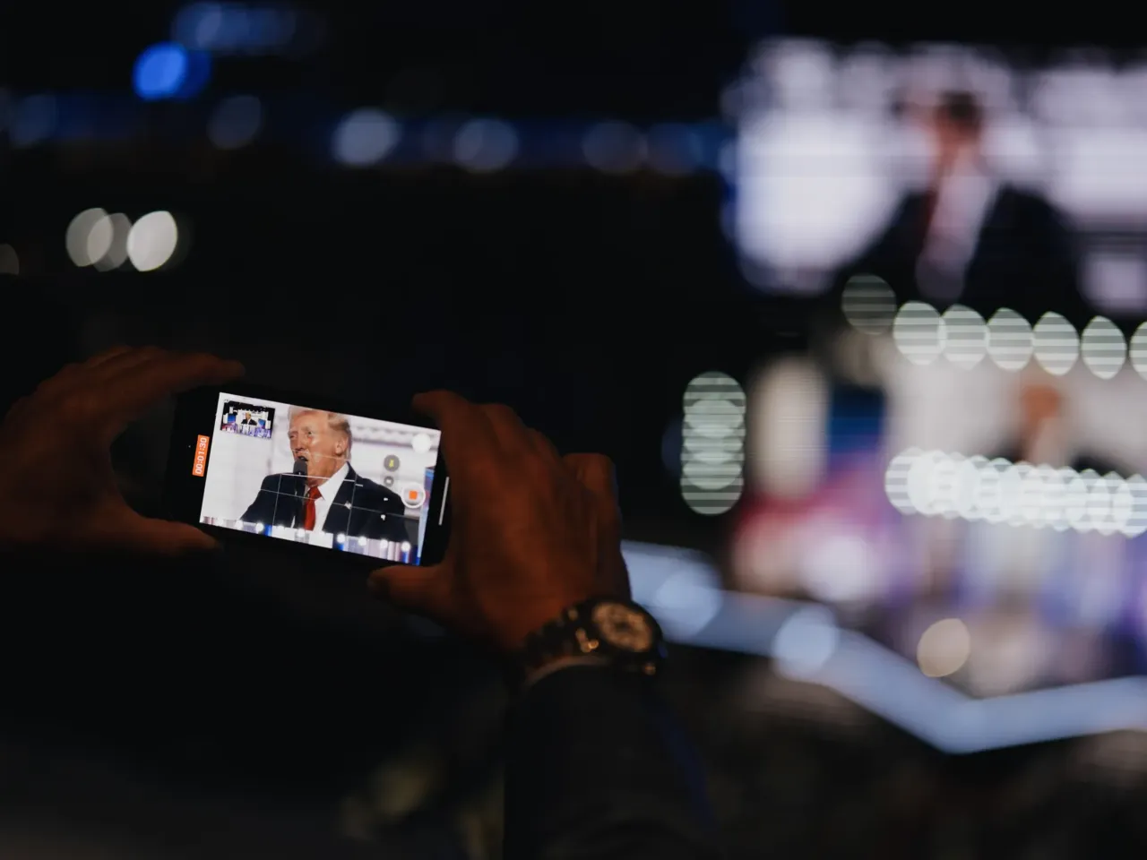 A man records Donald Trump speaking on his phone on the final night of the Republican National Convention.