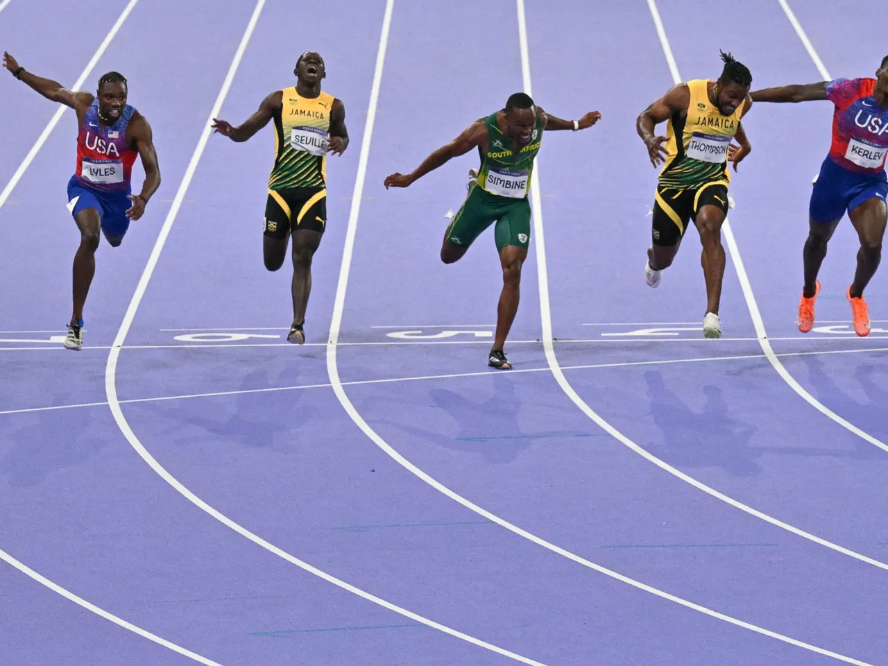The U.S.'s Noah Lyles (L) crosses the finish line just ahead of Jamaica's Kishane Thompson (2R), USA's Fred Kerley (R), South Africa's Akani Simbine (C) and Jamaica's Oblique Seville (2L) in the men's 100m final of the athletics event Sunday at the Paris 2024 Olympic Games.