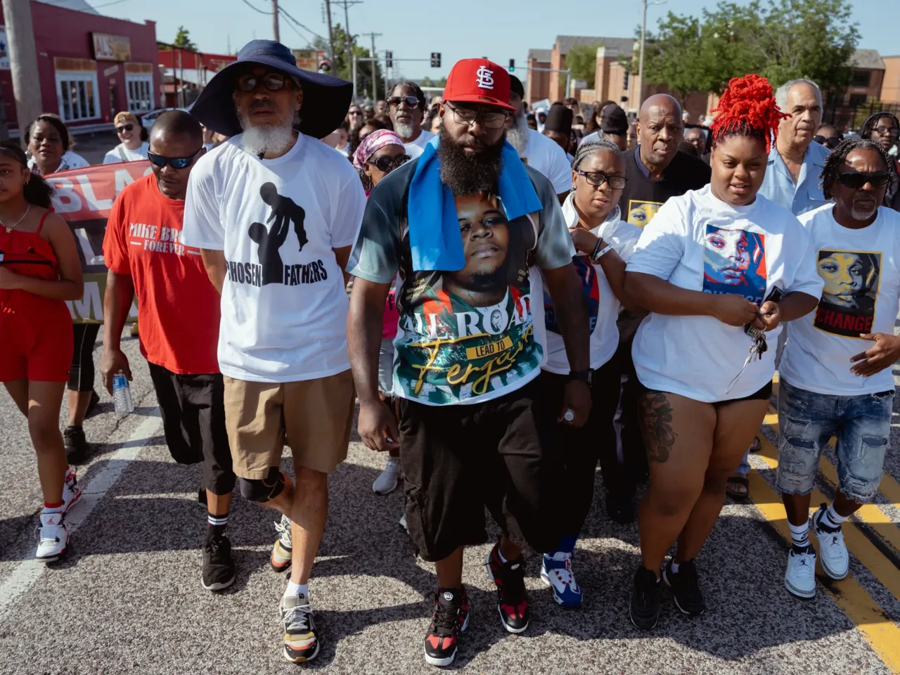 Michael Brown Sr., center, leads a unity march commemorating a decade after Michael Brown Jr.’s police killing on Friday, Aug. 9, 2024, outside of Normandy High School in Normandy. Michael Brown Jr., his son, was killed by a Ferguson police officer in 2014 only days after graduating from high school.