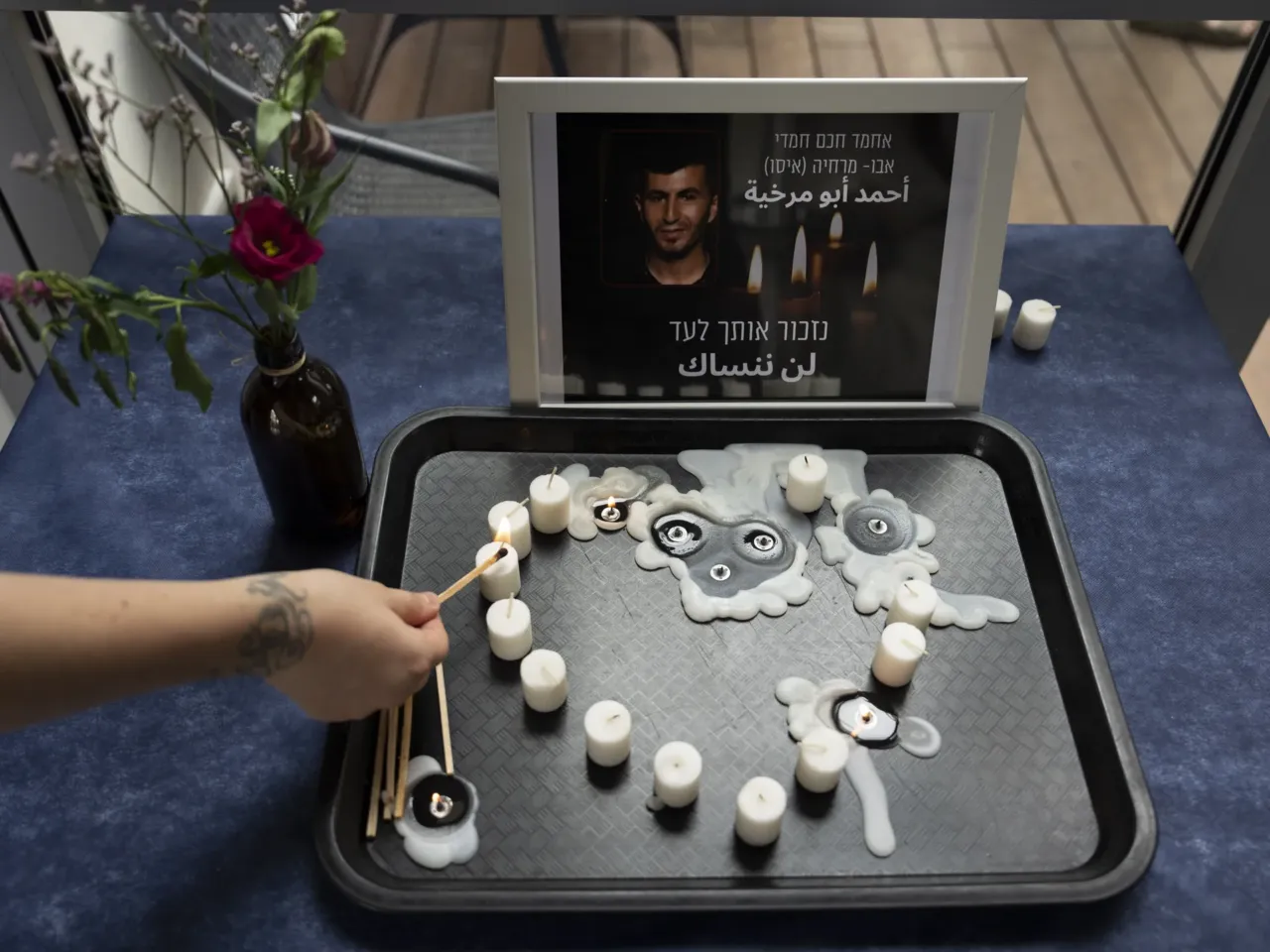 At an LGBTQ+ shelter in Tel Aviv, Israel, on Oct. 7, 2022, a volunteer lights a candle during a vigil for Ahmad Abu Markhiya, a 24-year-old Palestinian man who was found decapitated in the West Bank city of Hebron.