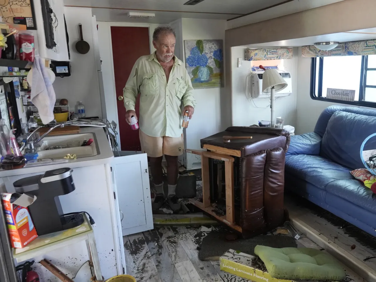 Fred Hill gets a few drinks from his destroyed home after it was hit by a tornado and flooding caused by Hurricane Milton, Thursday, in Matlacha, Fla.