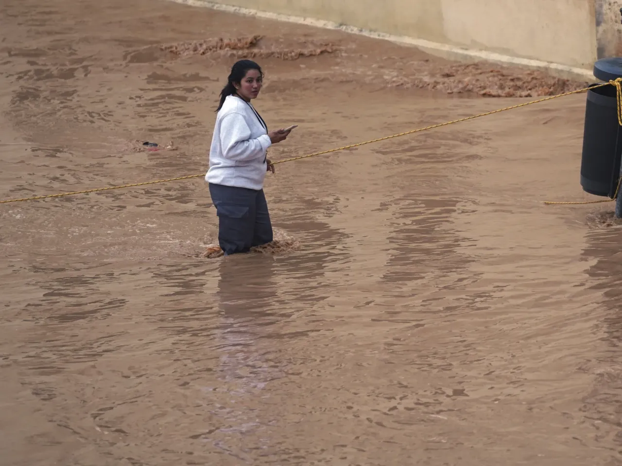 A woman walks through flooded streets in Valencia, Spain.