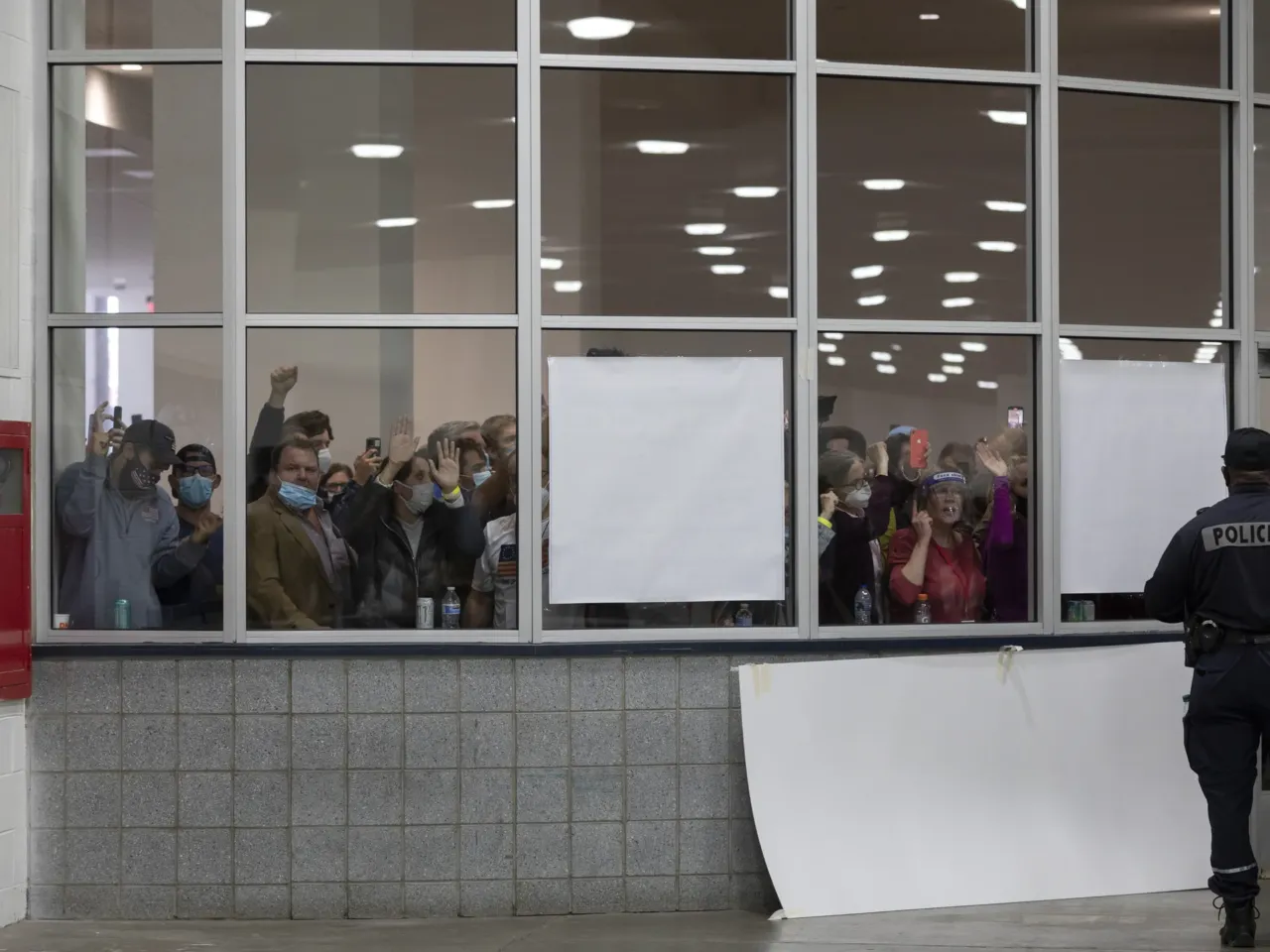 A crowd chants "Stop the count!" and pounds on the windows and doors after partisan election challengers were told that the capacity for election challengers had been met in the counting facility at what was then Detroit's TCF Center on Nov. 4, 2020.
