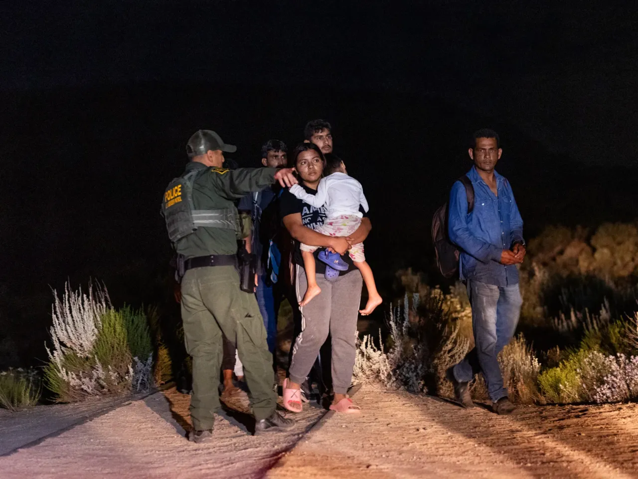 Migrants queue up to be processed by U.S. Border Patrol agents after crossing into the U.S. from Mexico through an abandoned railroad on June 23, 2024 in Jacumba Hot Springs, San Diego, California.