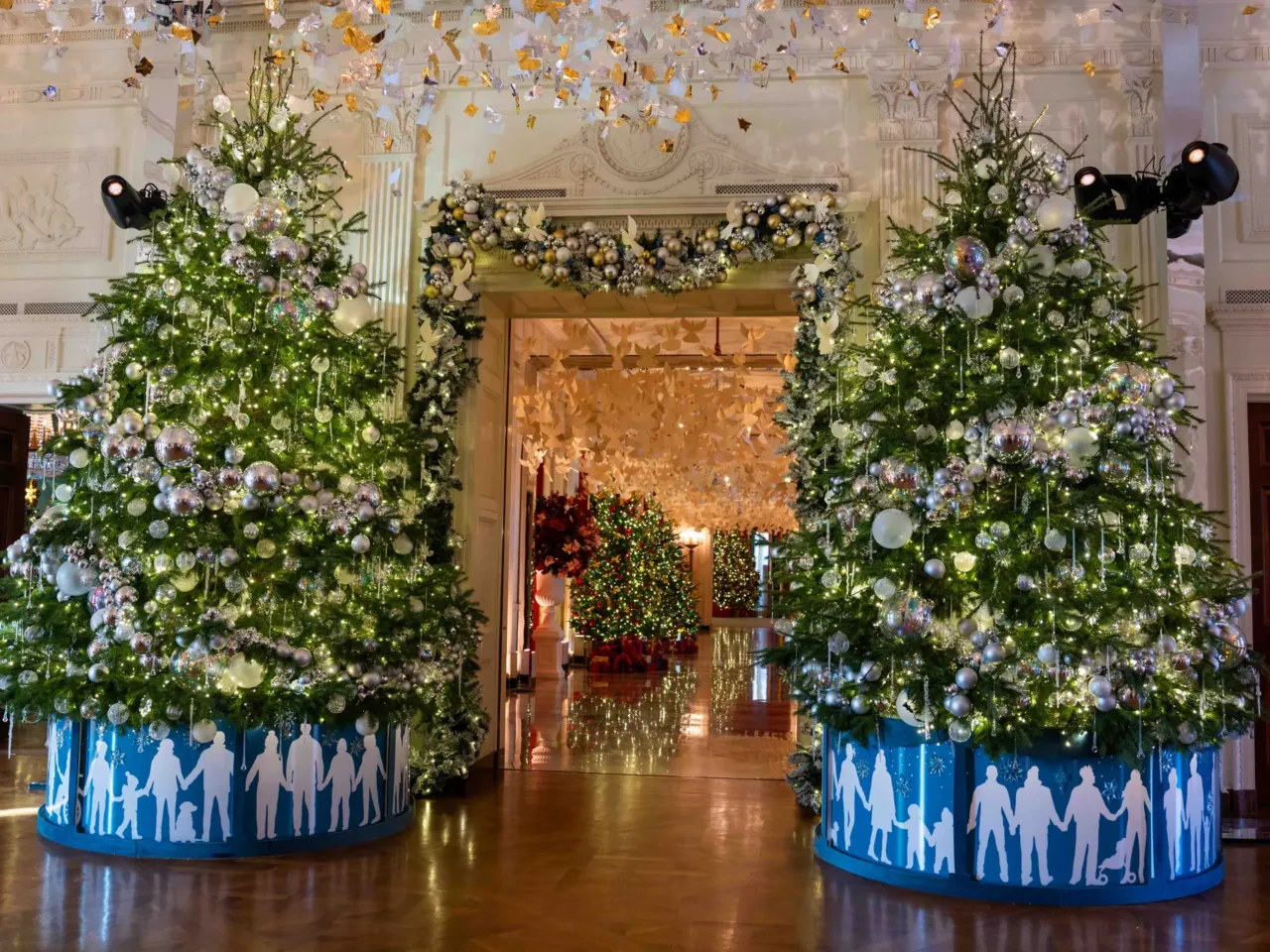 Decorated trees in the East Room frame the Cross Hall of the White House.