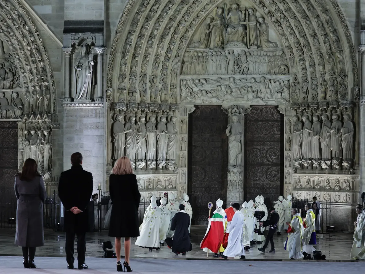 Mayor of Paris Anne Hidalgo (left), French President Emmanuel Macron (second from left) and his wife Brigitte Macron (third from left) stand as the Archbishop of Paris, Laurent Ulrich (center), walks to the doors of Notre Dame Cathedral during a ceremony to mark the reopening on Saturday.
