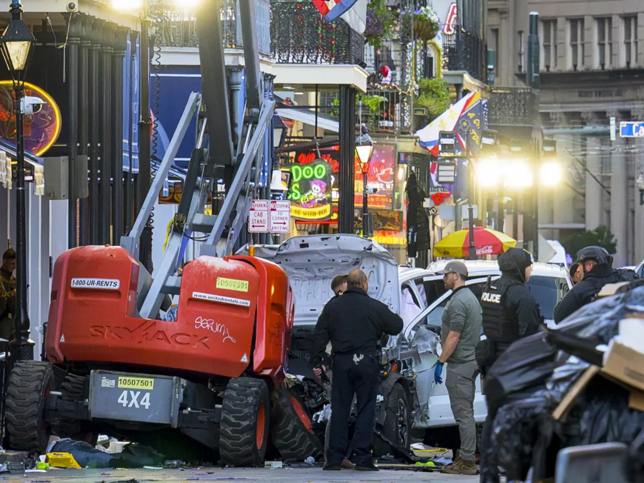 Police investigators surround the white Ford F-150 pickup truck that crashed into a work lift after allegedly driving into a crowd of New Year's revelers in the French Quarter of New Orleans.