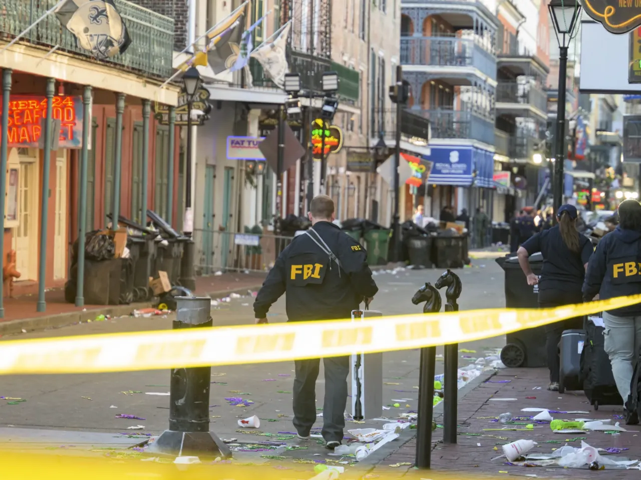 FBI investigators arrive at the scene where the white Ford F-150 pickup truck that crashed into a work lift after allegedly driving into a crowd of New Year's revelers in the French Quarter of New Orleans.