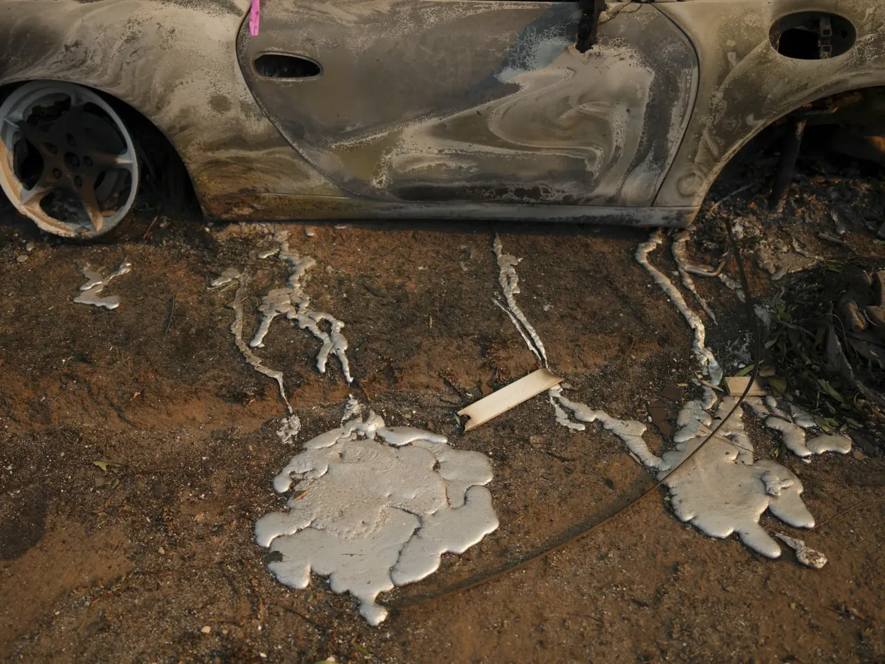 Friday, Jan. 10: Melted metal from a burned vehicle is seen on the ground of a property in the Pacific Palisades neighborhood.
