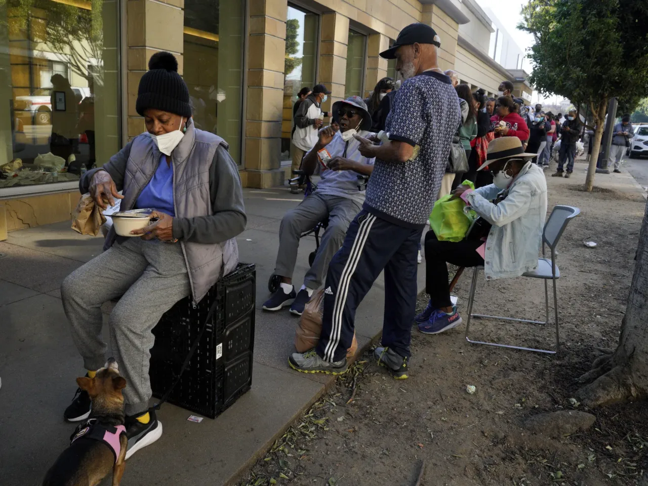 Friday, Jan. 10: Betty Comas, left, waits in line with her dog at an aid center for those affected by wildfires at the Pasadena Convention Center.