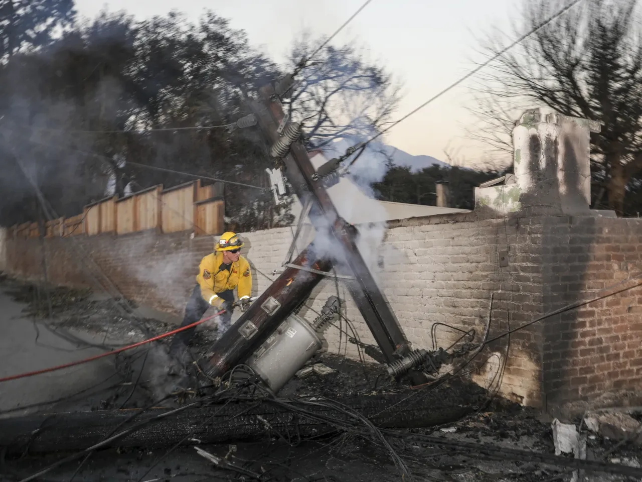 Friday, Jan. 10: Firefighter works to extinguish a still smoldering fire in Altadena