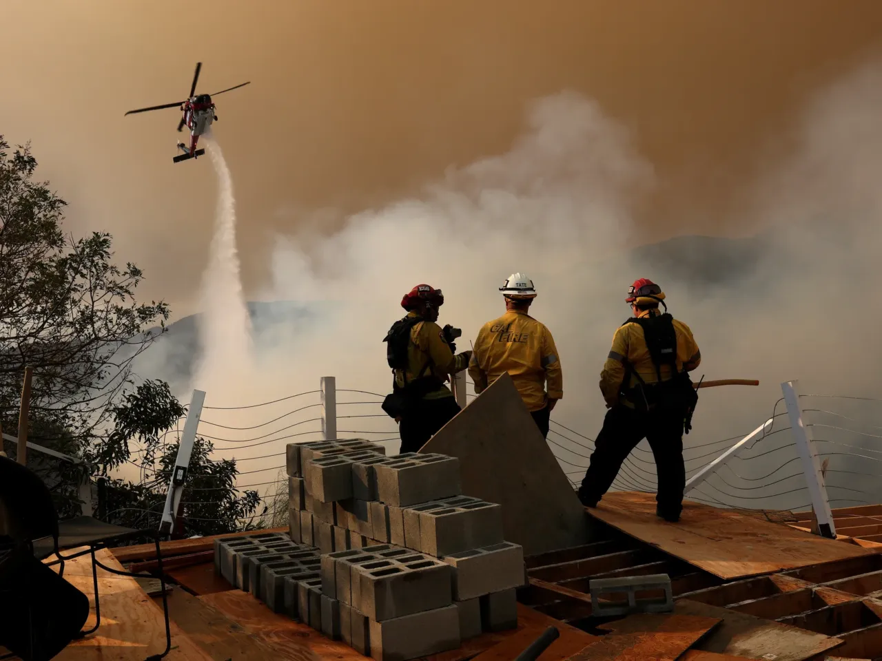 Sat., Jan. 11: A firefighting helicopter drops water on the Palisades Fire in Los Angeles, California.