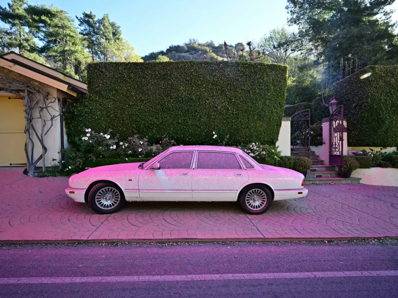 Sunday, Jan. 12: Fire retardant covers a car and sidewalk in the Mandeville Canyon neighborhood of Los Angeles, as the Palisades Fire continues to threaten the city.