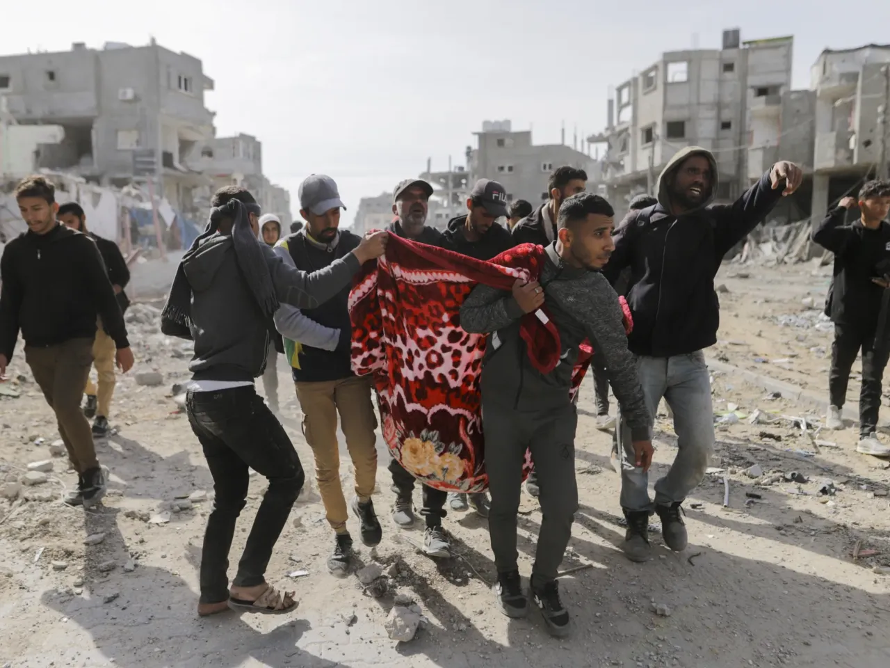 Palestinians carry a wounded man through the streets of Rafah, Gaza Strip, on Jan. 19, 2025.