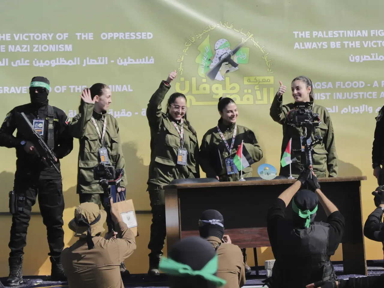 Israeli female soldier hostages wave at a Palestinian crowd before being handed over to the Red Cross in Gaza City, Saturday, Jan. 25, 2025.