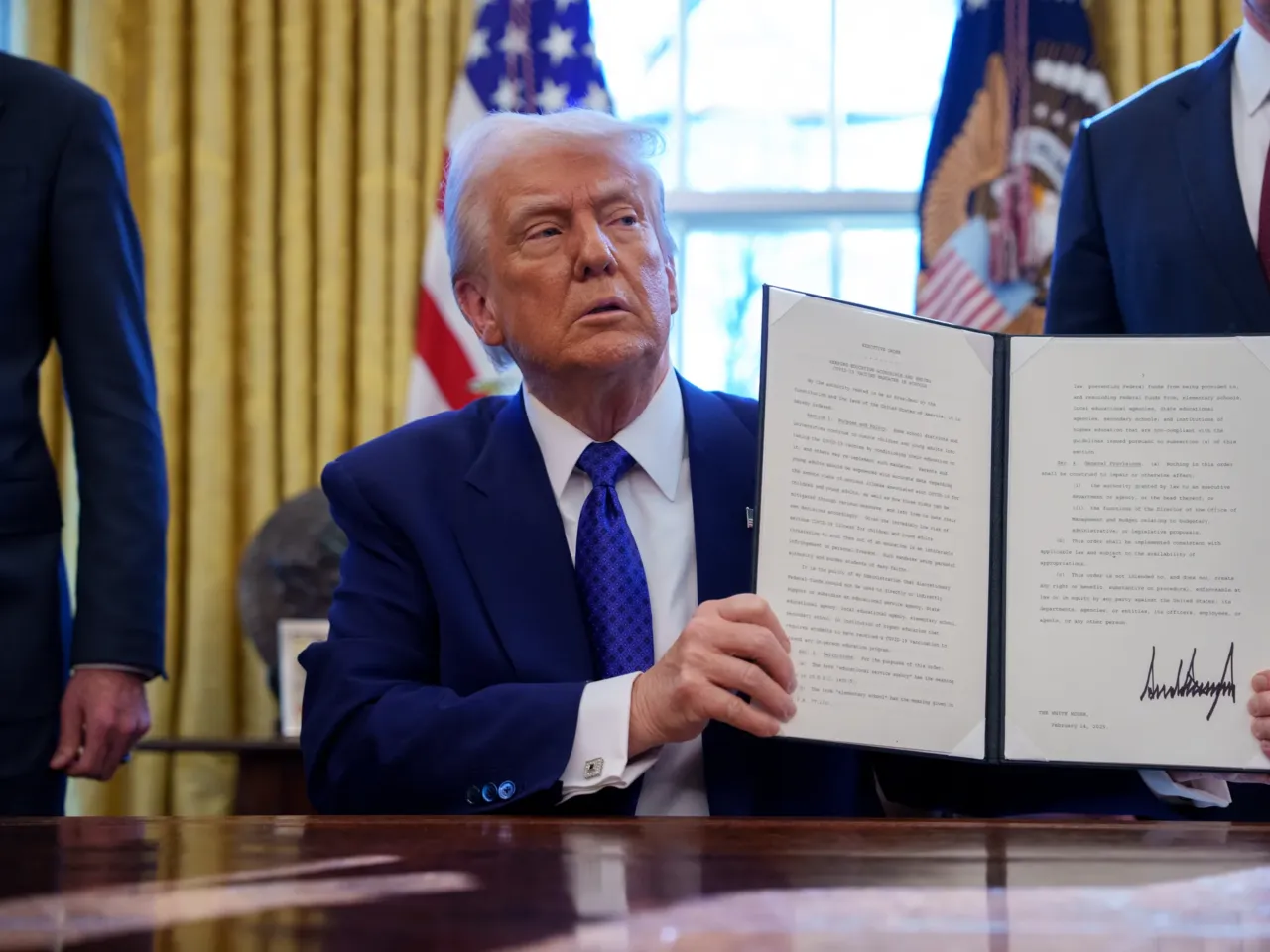 President Donald Trump signs an executive order withholding federal funding from schools and universities that impose a COVID-19 vaccine mandate in the Oval Office on Feb. 14, 2025. Many of Trump's executive actions are facing legal challenges in the courts.