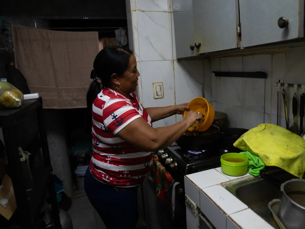 Esther Castañeda, Samuel Ricaurte Castañeda's wife, prepares seafood rice and beans for his birthday. The couple live in an apartment building constructed after the 1989 invasion.