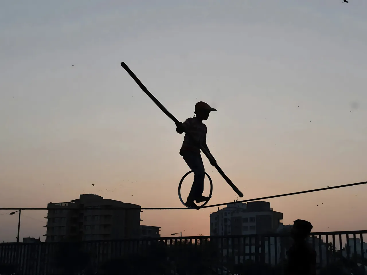 Awinash Kulkarni, 56, became a paraplegic at the age of 21, when he fell 50 feet from the wall of the Bhushi Dam in Lonavala. In this photo from his work, he shows a young person entertaining folks with a high-wire act. Kulkarni says he fears for the safety of this young daredevil.