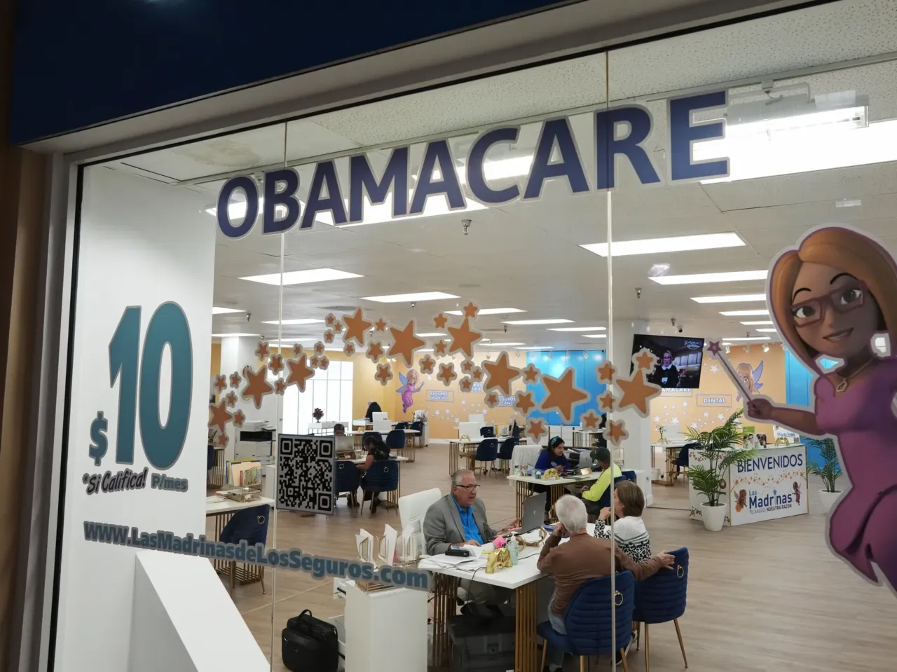 An insurance agent talks with clients inside a shopping center in Miami, on Dec. 5, 2023. Once someone enrolls in an Affordable Care Act plan, they can get help with sticky insurance issues from caseworkers at the federal government. Many caseworkers were cut in the recent round of federal layoffs.