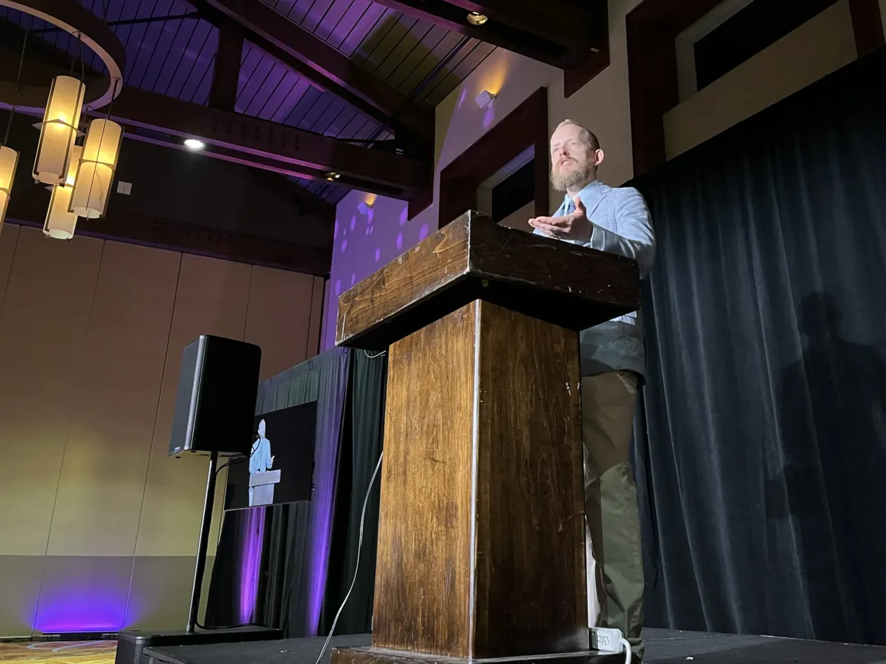 Natal Con's organizer, Kevin Dolan, speaks to attendees in Austin, Texas. He said on his podcast that modern culture and government policies have created a "badly dysfunctional" "breeding system" in which excellence is devalued.