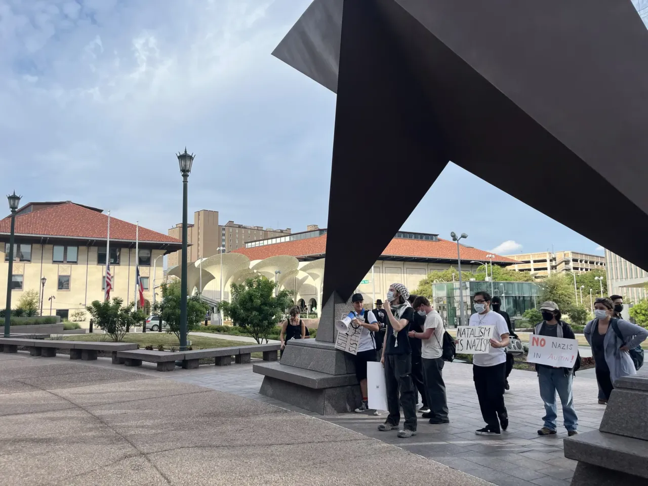 A small group of student protesters from the adjoining University of Texas at Austin gathers outside Natal Con.