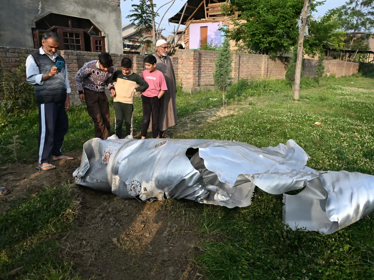 India-Pakistan ceasefire holds for a 2nd day 1 People look at the debris of an aircraft in Wuyan, a village in the Pulwama district in Indian-administered Kashmir, May 7.