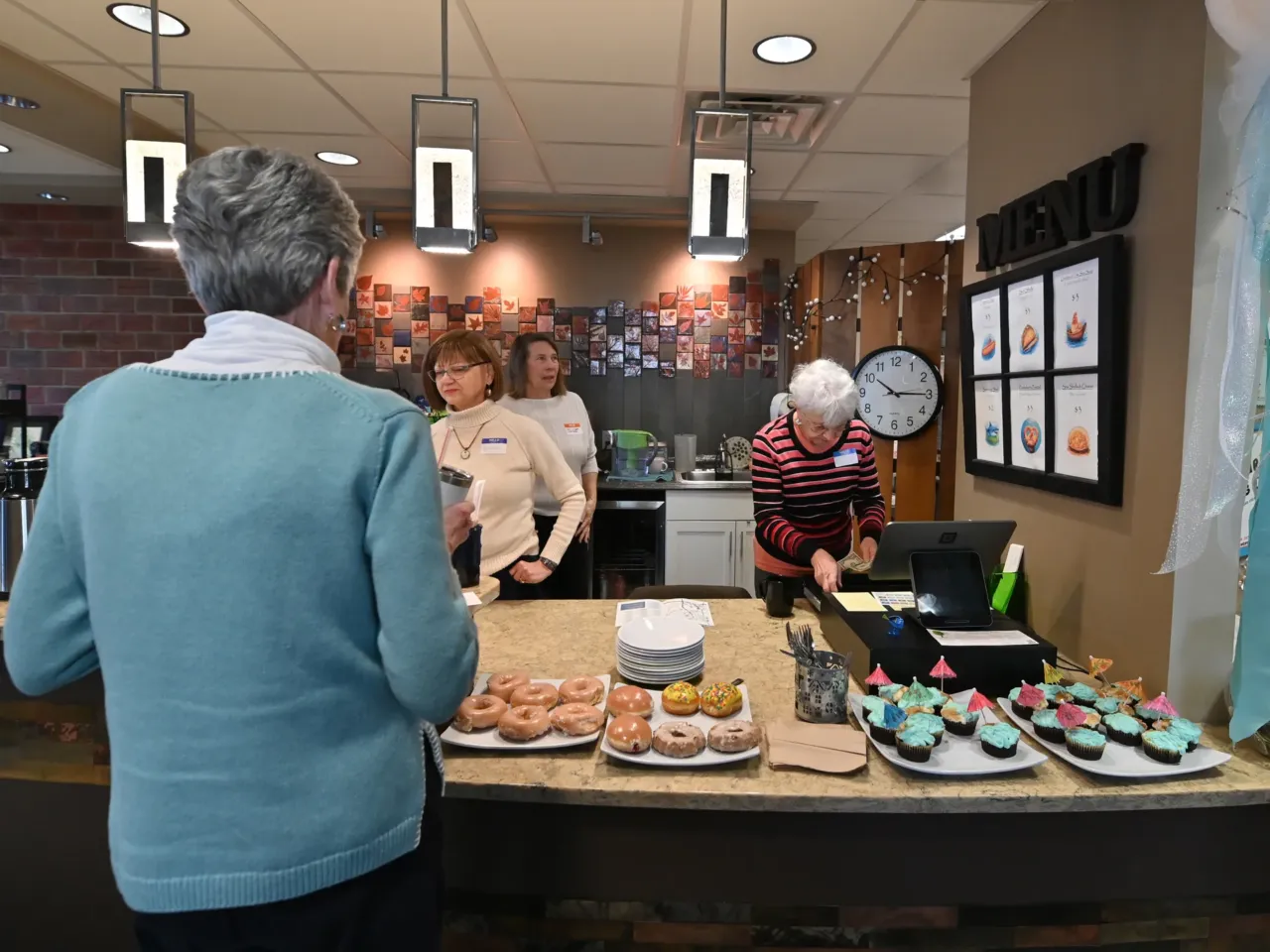As things get underway at the memory cafe in Clarks Summit, Penn., guests help themselves to breakfast pastries.