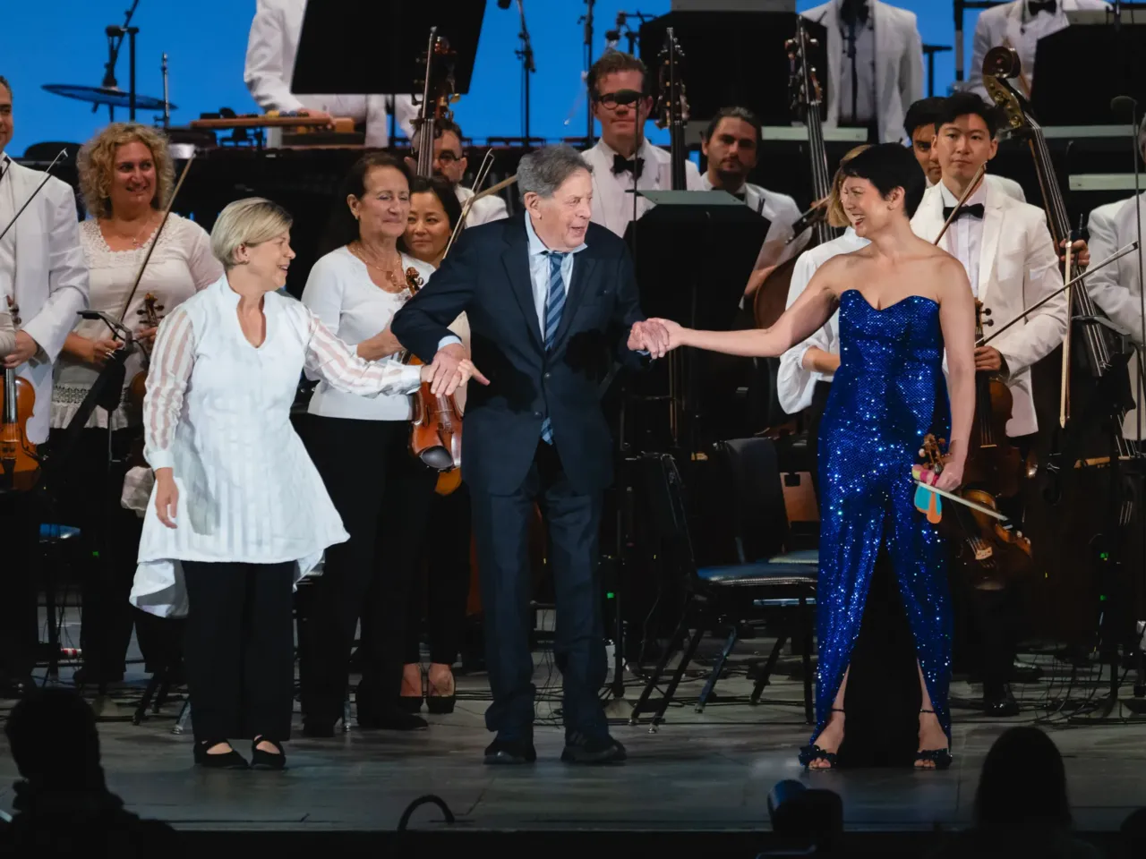 Philip Glass (center) composed his New Chaconne for violinist Anne Akiko Meyers (right) after hearing her perform his Violin Concerto No. 1 with the Los Angeles Philharmonic under the baton of Karen Kamensek (left).