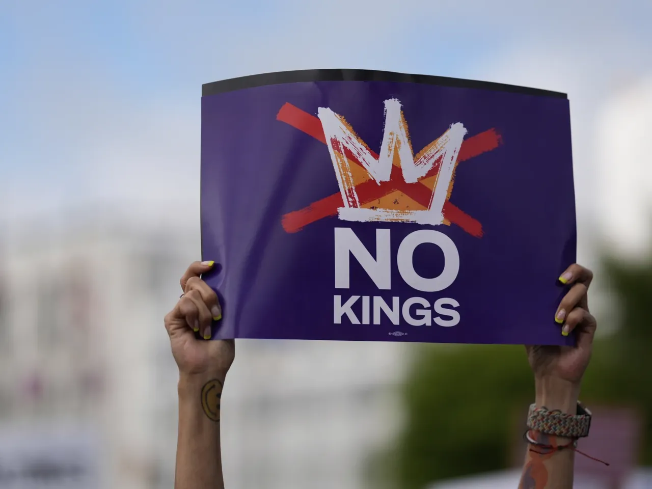 Anti-Trump No Kings protests flood American streets ahead of military parade 2 A demonstrator holds a sign during a "No Kings" protest, Saturday, June 14, 2025, in Atlanta.