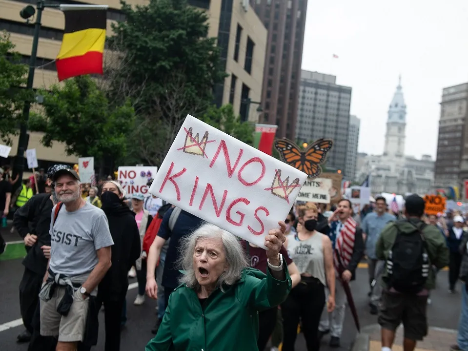 3 takeaways from the military parade and No Kings protests on Trump's birthday 5 A protester holds a placard during a march down the Benjamin Franklin Parkway to the Philadelphia Museum of Art during a nationwide No Kings rally in Philadelphia on Saturday.