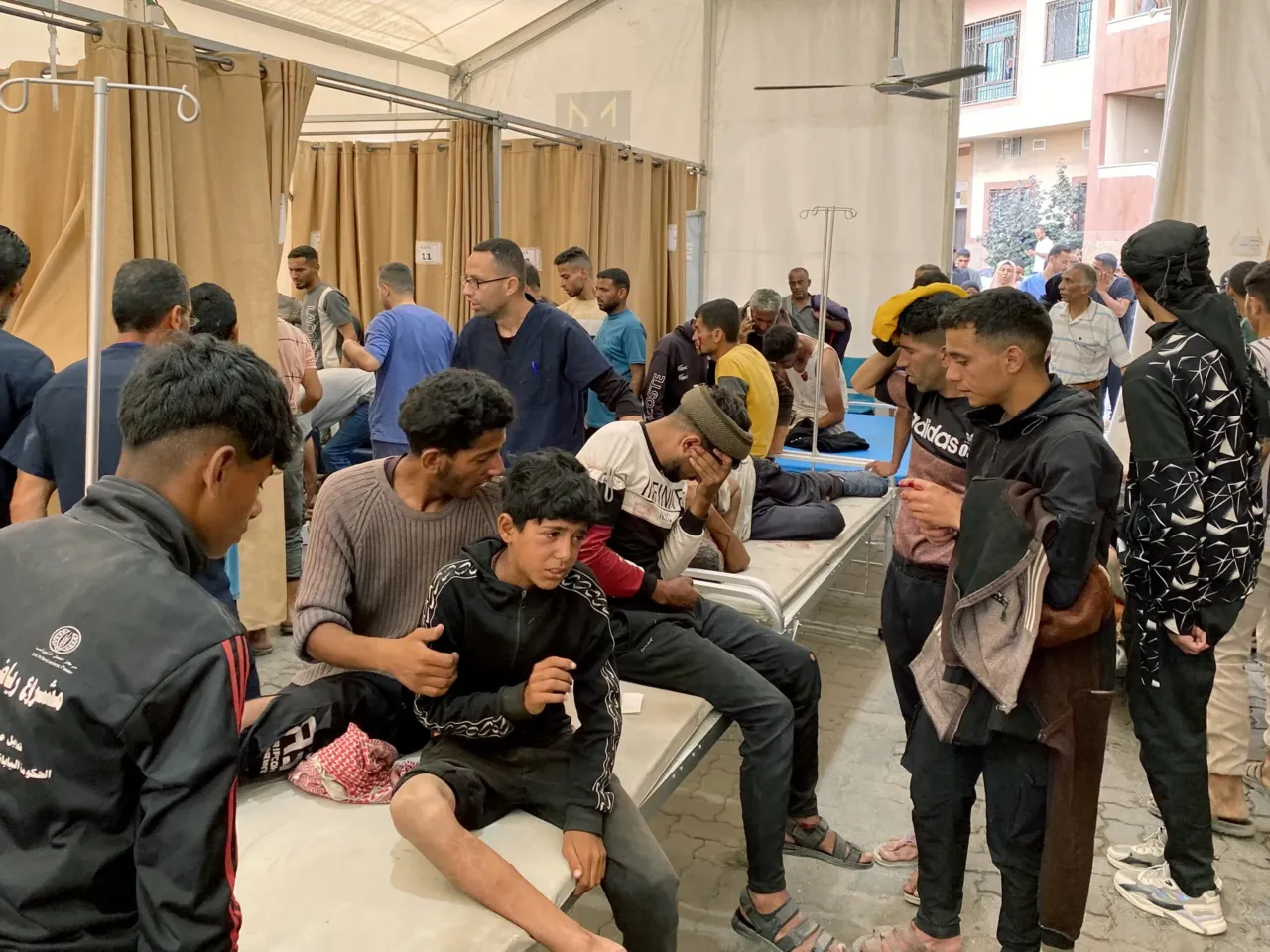 As Israel turns its focus to Iran, the death toll mounts in Gaza — and hunger deepens 2 Palestinians injured in Israeli fire as they gathered near a food aid center receive care at Khan Younis' Nasser hospital in the southern Gaza Strip on Tuesday.