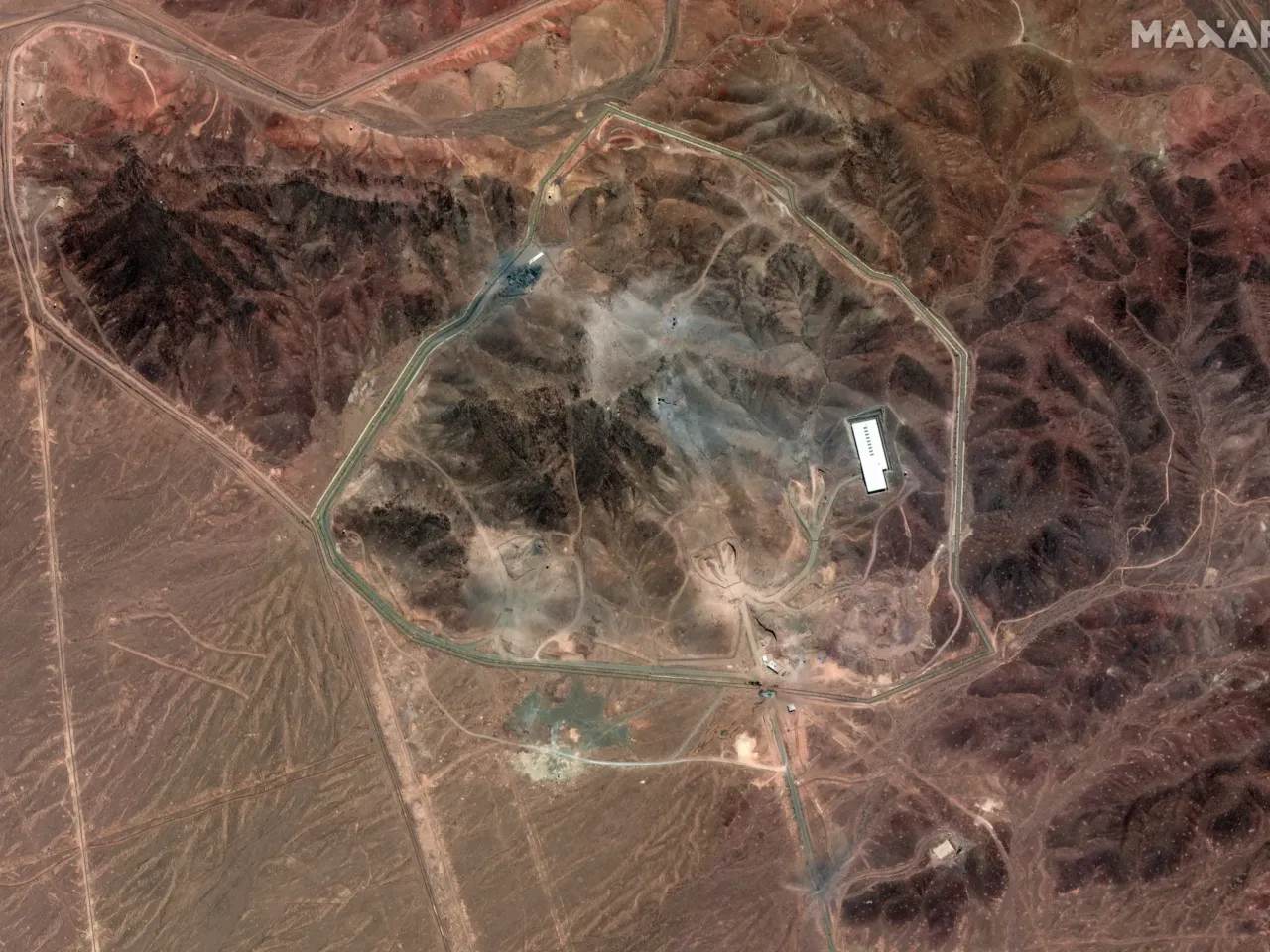 A satellite photo of Iran's Fordo fuel enrichment facility taken on June 24 shows debris (grey) from a U.S. strike employing several bunker-busting weapons. The Israeli Air Force destroyed additional roads and surface facilities in a subsequent strike.
