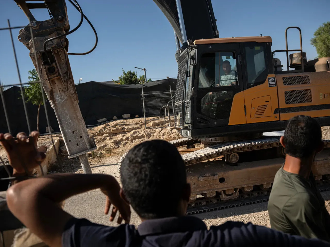 A Palestinian activist was killed by the violence he sought to stop 4 Palestinians mourning the killing of activist Awdah Al Hathaleen watch as the same excavator involved in the confrontation that led to his death is driven through the village of Umm al-Khair in the West Bank, returning to the Carmel settlement after working on a construction project beside the village, Aug. 4.