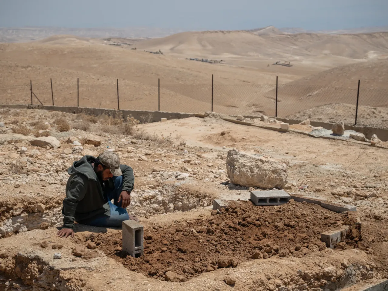 A Palestinian activist was killed by the violence he sought to stop 8 Tariq Hathaleen, a cousin of Awdah Hathaleen and a community leader, sits alone beside Hathaleen's grave shortly after his funeral on Aug. 7, in Umm al-Khair, West Bank.