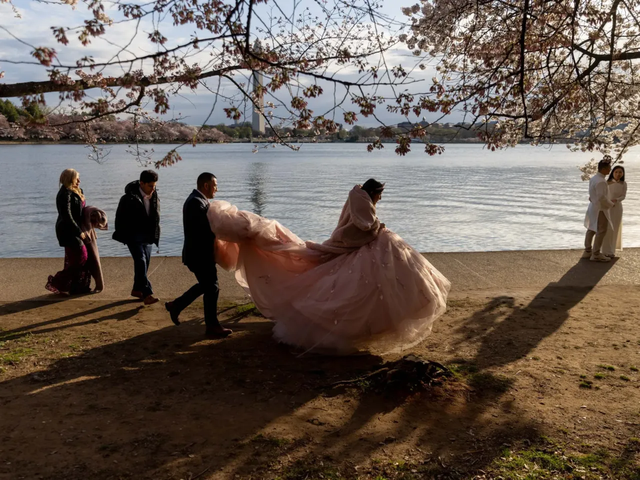 Here, together: Images of community from NPR station photographers 8 Gabriella Cardenas, 15, wears her quinceañera dress as she and her father, Boris Cardenas, who's carrying her dress, her brother, Jason Cardenas, 17, and her mother, Patricia Cardenas, move to a new spot along the Tidal Basin for a photo on Wednesday, March 26, 2025 in Washington, D.C.