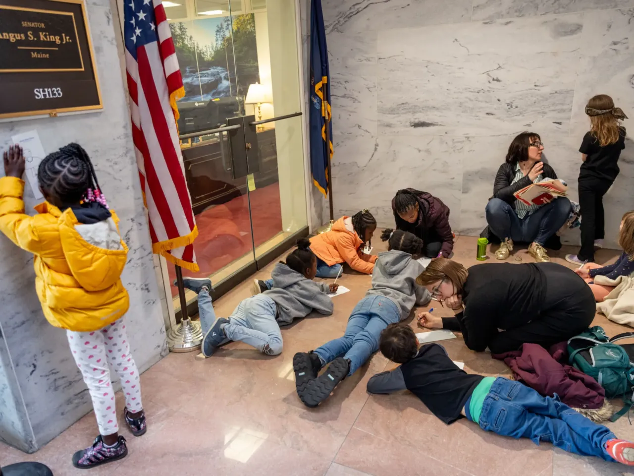 Here, together: Images of community from NPR station photographers 12 Students and parents from Washington, D.C.'s Elsie Whitlow Stokes Community Freedom Public Charter School, East End Campus, write letters outside of the office of Sen. Angus King, I-Maine. They handed those letters to the staff in order to convince the member to vote "no."