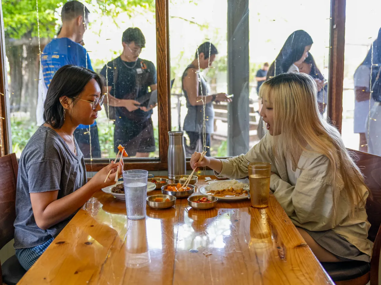 Here, together: Images of community from NPR station photographers 13 College students Agatha Angeles (left) and Nancy Yeung (right) eat at Korea House on a free meal day, when anyone who visits the restaurant can dine at no cost, on Wednesday, July 3, 2025. On the first Wednesday of every month, Korea House offers a free meal to serve their community.