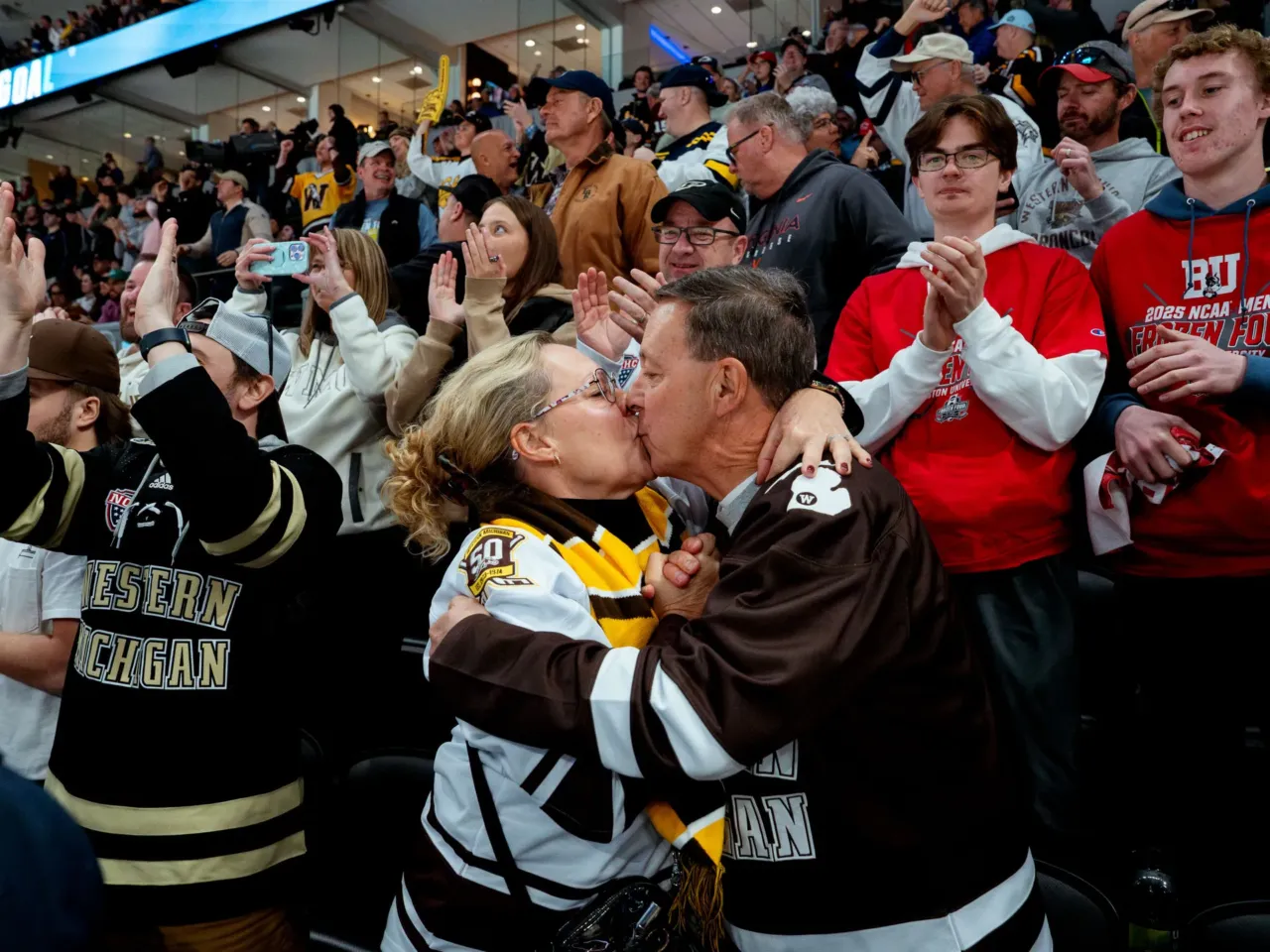 Here, together: Images of community from NPR station photographers 15 Todd and Amy Sanford, of Kalamazoo, Mich., kiss after the Western Michigan Broncos score another goal, ultimately defeating the Boston University Terriers and clinching the team's first-ever NCAA men's ice hockey championship on Saturday, April 12, 2025, at the Enterprise Center in downtown St. Louis.