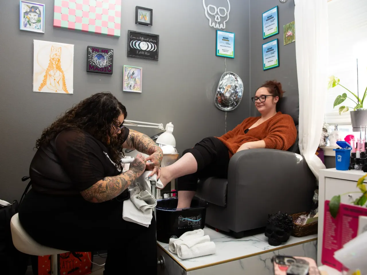 Here, together: Images of community from NPR station photographers 17 Kasia Moon (left) removes gel nail polish from her colleague's toe nails at her salon in Bend, Ore., on Nov. 15, 2024.