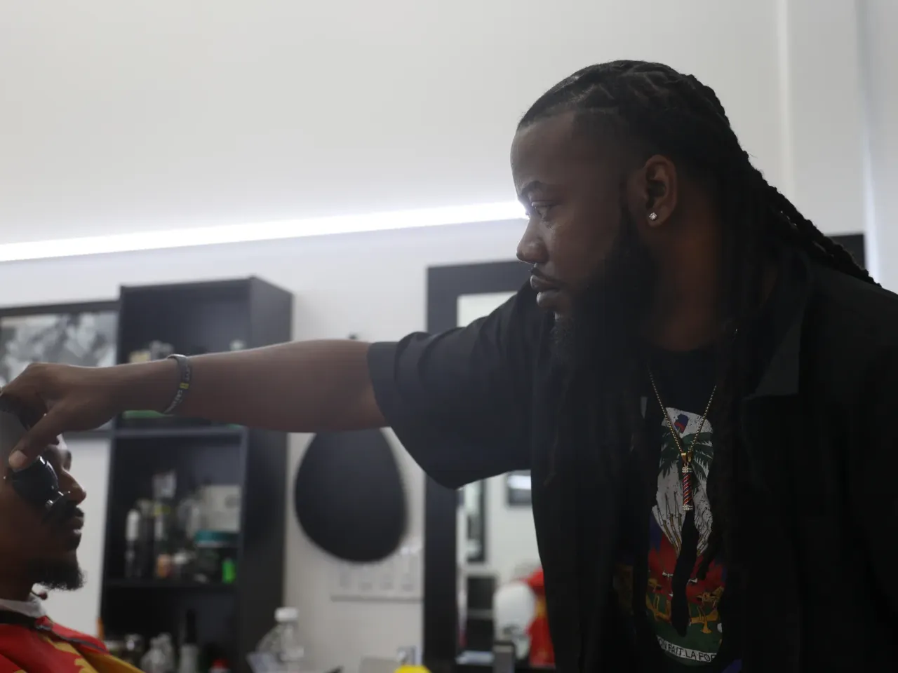 Caption: John "Speedy" Riddle works in A Shaving Grace Barbershop in the southeast Houston area. Riddle moved to Houston at the age of 15 after Hurricane Katrina destroyed his family home.