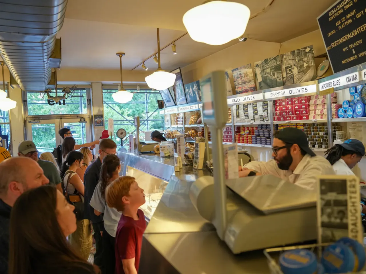 Russ & Daughters in NYC celebrates '100 years of appetizing' and family 3 Customers order food over the counter at Russ & Daughters
