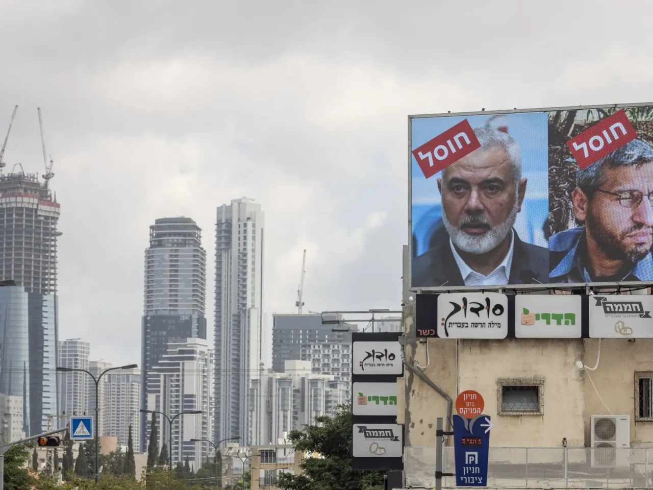 A billboard displays portraits of Hamas leaders Mohammed Deif and Ismail Haniyeh with the word "assassinated" in Hebrew, in Tel Aviv, Aug. 2, 2024.